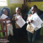 Schulkinder in Tansania zeigen stolz ihre neuen Schulmaterialien, die durch die Spenden ermöglicht wurden.